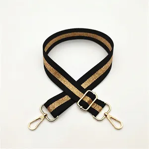 Adjustable black bag strap with gold metallic stripes and golden swivel hooks