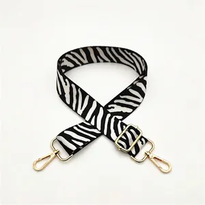 Detail of zebra pattern shoulder strap with gold hardware and lobster clasps
