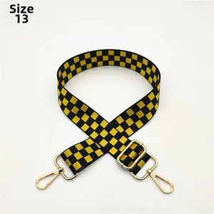 Close-up of No. 13 yellow and black checkered woven bag strap with golden lobster clasps