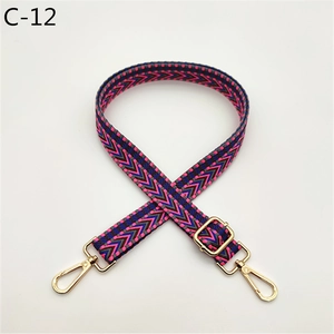 Detail of colorful geometric woven bag strap with golden lobster clasp and slider