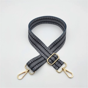 Close-up of adjustable black and white geometric wave strap with gold metal hardware