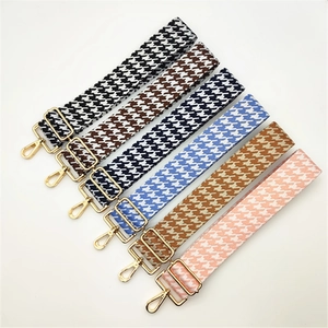 Détail de bandoulières réglables à motif pied-de-poule avec boucles en métal doré