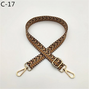 Detail of adjustable woven wide shoulder strap with chevron pattern and gold metal hooks