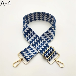 Détail de la bandoulière pied-de-poule bleu et blanc avec mousquetons en métal doré