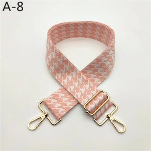 Détail de la bandoulière pied-de-poule rose avec boucle et crochet dorés réglables