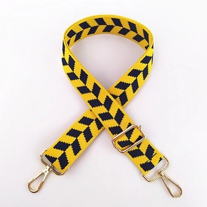 Close-up of yellow and black herringbone weave strap with pale gold metal hardware hooks