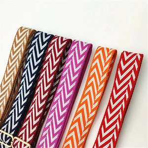 Detailed view of colorful woven bag straps with rhombus patterns and golden metal buckles