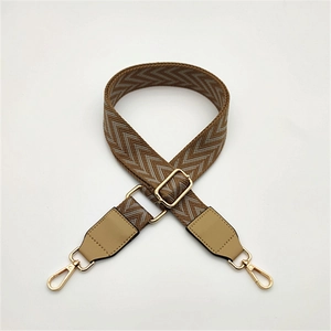 Close-up of adjustable diamond pattern purse strap with gold hooks and brown leather details