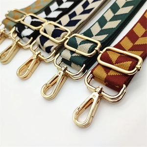 Detail of adjustable woven nylon shoulder straps with geometric patterns and gold metal hooks