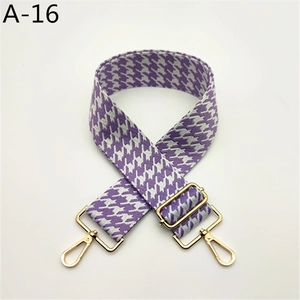 Détail d'une sangle pied-de-poule violette avec crochets et boucles en métal doré poli