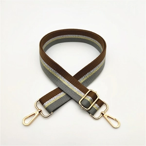 Close-up of adjustable striped handbag strap with gold metal buckles and woven texture