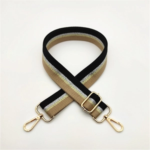 Detail of adjustable striped bag strap with gold metal lobster clasps and buckles