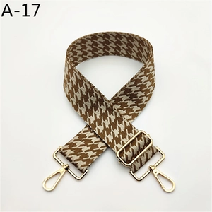 Détail d'une bandoulière pied-de-poule marron avec boucle en métal doré réglable
