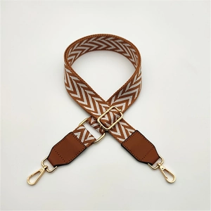 Detail of adjustable PU leather bag strap featuring brown chevron weaving and gold hardware