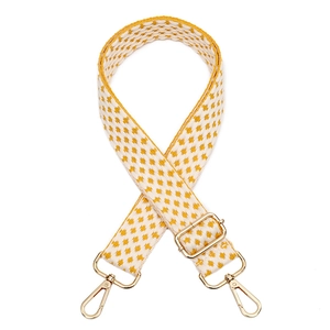 Detail of thickened woven purse strap with yellow geometric pattern and gold hardware