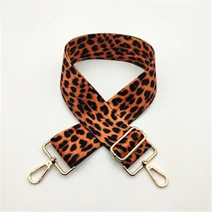 Close-up of leopard print bag strap with golden lobster clasps and metal buckle detail