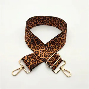 Detail view of leopard print bag strap with adjustable gold buckle and metal swivel hooks