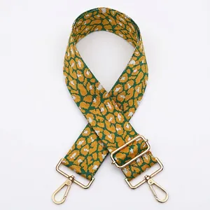 Detail of wide leopard print bag strap with golden metal buckle and lobster clasp
