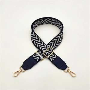 Detail of adjustable blue and white chevron pattern bag strap with gold metal lobster clasp