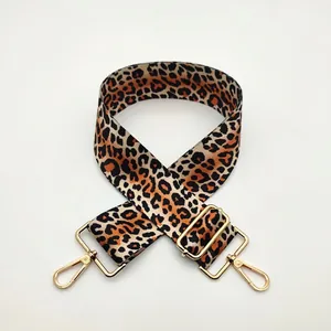 Detail of adjustable leopard print bag strap with golden metal lobster clasps and buckles