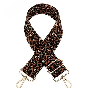 Close-up of leopard print bag strap with golden metal hooks and adjustable buckle