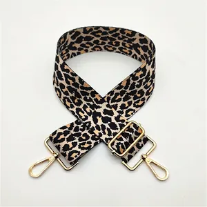 Detail of adjustable leopard print bag strap with polished gold metal swivel hooks