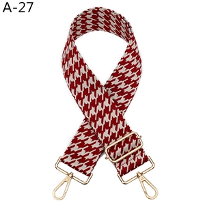 Vue détaillée de la sangle pied-de-poule rouge et blanche avec boucle dorée réglable