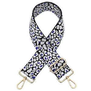 Detail view of the leopard print bag strap with adjustable gold metal buckle hardware