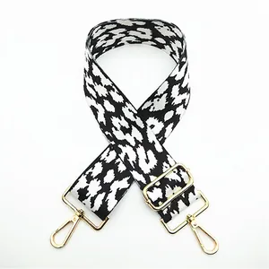 Detail of adjustable leopard print bag strap with golden lobster clasps and buckles