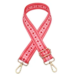 Detail of Style 21 woven bag strap with pink and red rhombus pattern and gold hardware