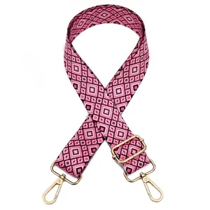 Close-up of adjustable pink floral guitar strap with geometric pattern and gold hardware
