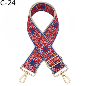 Detail of bohemian embroidery purse strap with geometric floral pattern and gold metal hooks