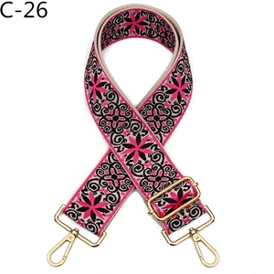 Detail of adjustable floral bag strap with pink and black ethnic embroidery and gold hooks