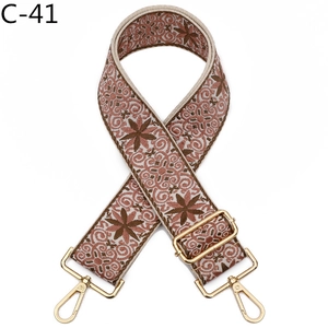Detail of pink ethnic jacquard bag strap with gold lobster clasps and geometric pattern