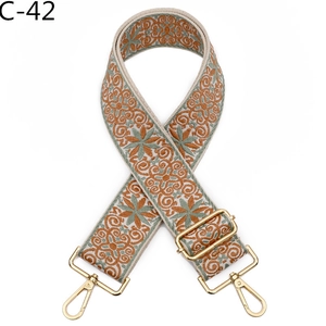 Detail view of Bohemian wide fabric strap with floral embroidery and gold metal hooks