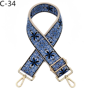 Detailed view of vintage ethnic embroidery bag strap with gold metal buckles and swivel hooks