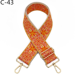 Close-up of bohemian orange floral woven bag strap with polished gold metal swivel hooks