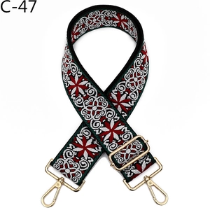 Macro detail of ethnic style embroidered bag strap with golden metal lobster clasps