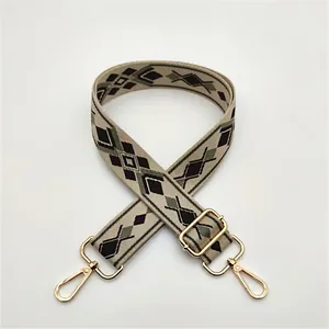 Close-up of adjustable woven canvas shoulder strap with vintage argyle pattern and gold hooks