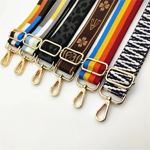 Detail of adjustable woven bag straps with diverse patterns and gold lobster clasps