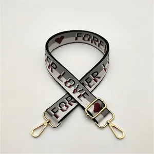 Adjustable off-white bag strap with red hearts and Forever Love text, gold metal hooks