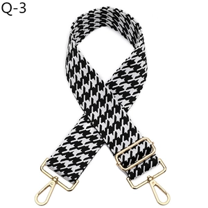 Detail of adjustable black and white houndstooth bag strap with gold metal lobster clasps