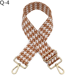 Detail of jacquard houndstooth strap in brown and white with gold lobster clips