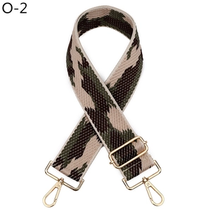 Detail of adjustable bag strap with green wave patterns and golden metal hooks