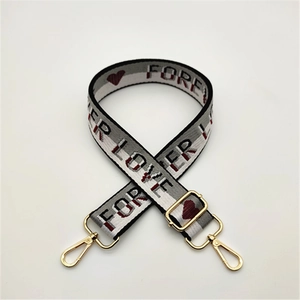 Adjustable woven replacement bag strap with gray jacquard hearts and gold metal buckles