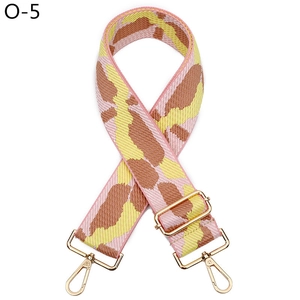 Close-up of wide adjustable strap with pink yellow brown patterns and gold metal hooks
