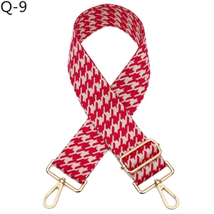 Detail of red houndstooth woven wide strap with gold-tone metal hooks and buckles