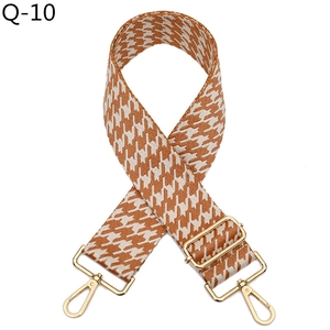 Detail of adjustable houndstooth shoulder strap with golden metal swivel snap hooks