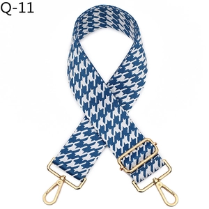 Detail of blue houndstooth wide strap with golden metal swivel hooks and adjustable buckle