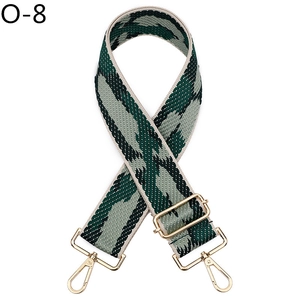 Detail of adjustable wide shoulder strap with green geometric pattern and gold buckles